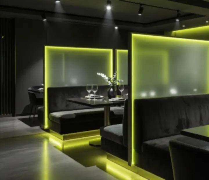 Salle de restaurant sombre avec éclairage vert acide et ambiance lounge