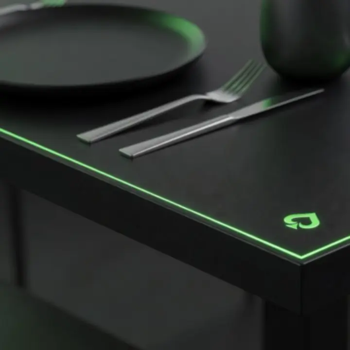 Détail de table sombre avec accents vert acidulé et motifs inspirés de jetons.