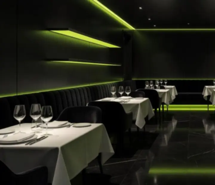 Salle du restaurant Monteloria G en soirée, éclairage vert acidulé et ambiance feutrée.