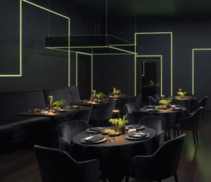 Salle événementielle Monteloria G avec tables dressées et ambiance sombre vert acide